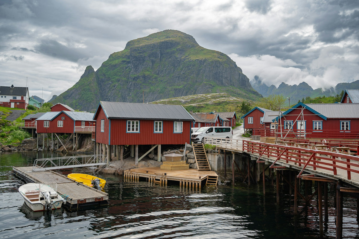 Rote Fischerhütten und Boote in einem norwegischen Fjord auf den Lofoten
